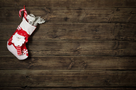 圣诞长袜和礼物挂在黑暗的旧木制背景