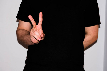 Young signlanguage interpreter, showing a V in American Sign 