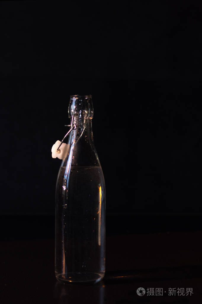 饮用水装在玻璃瓶中冷光源照射背景为黑色