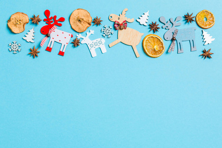 蓝色背景的假日装饰品和玩具的俯视图。圣诞装饰概念，为您设计一个空的空间