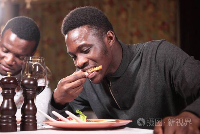 两个非裔美国学生在餐馆吃饭左边的那个人没注意到休息休假的概念宏观