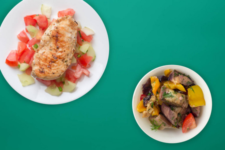 Grilled chicken breast with tomato salad, cucumbers and onions. 