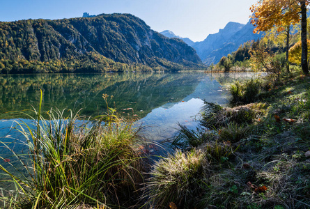 Peaceful autumn Alps mountain lake with clear transparent water 