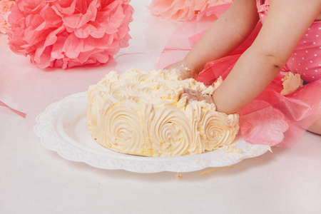 吃蛋糕的小女孩双手放在白色的背景上.这孩子全身都是食物.