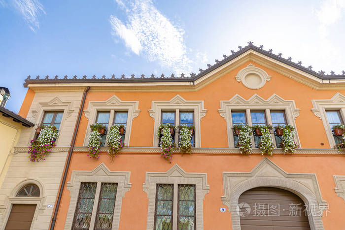 一个漂亮的橙色房子的正面挂着挂着地板的篮子