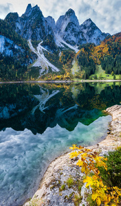 Peaceful autumn Alps mountain lake with clear transparent water 