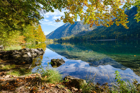 Peaceful autumn Alps mountain lake with clear transparent water 