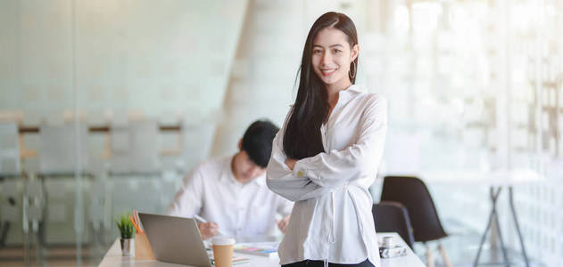 Portrait of young beautiful female designer standing and smiling