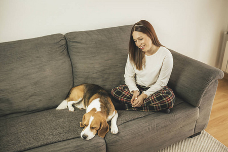 年轻女子带着她的狗在家里教练图片