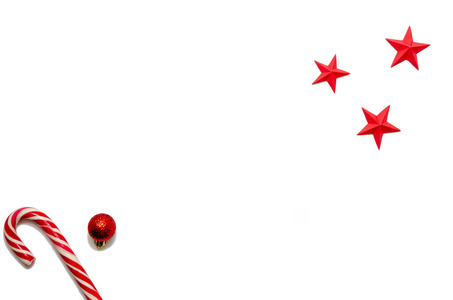 圣诞节和新年的最小组成部分，复制空间由糖红色圣诞球白色背景上的星星组成。寒假概念。平躺。俯视图
