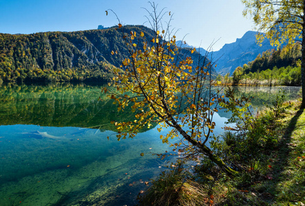 Peaceful autumn Alps mountain lake with clear transparent water 