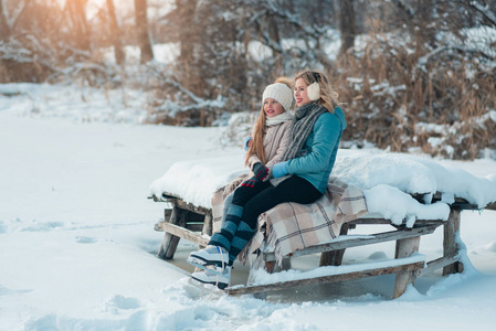 在一个冰雪覆盖的公园里，年轻的家庭在冰区玩得很开心