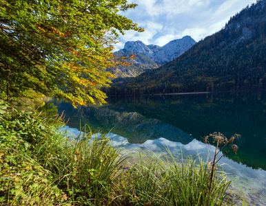 Peaceful autumn Alps mountain lake with clear transparent water 