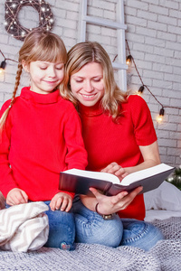 圣诞节快乐的妈妈和孩子们在家看书