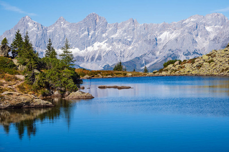 Calm autumn Alps mountain lake with clear transparent water and 