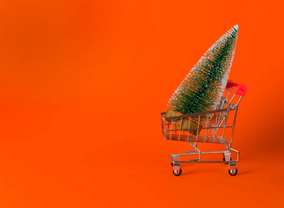 圣诞节，新年的心情在红色的背景上。绿色圣诞树超市手推车