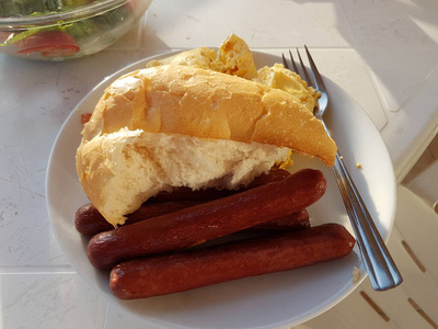 煎蛋卷配全麦面包和烤香肠。美味的早餐。阳光下的早餐