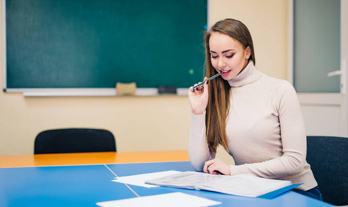 坐在讲堂里的年轻美女的肖像,在黑板上读教学大纲.学生和学校理念.