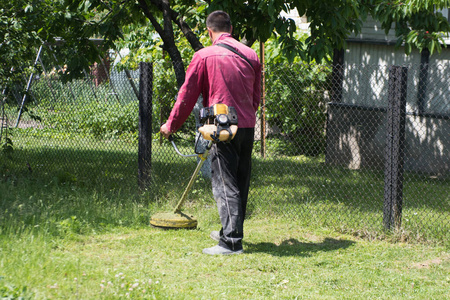 A man mows the grass on the lawn mowers. Overalls and tools. 