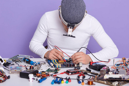 专业放射学家用专用电子设备检测电子板的电压,电流和电阻的水平图.