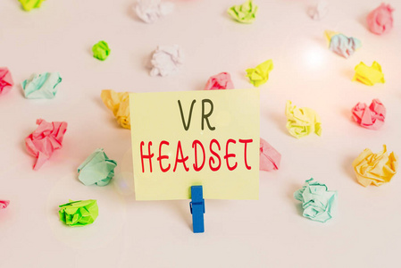 文字文字Vr耳机。为佩戴者提供虚拟现实的头戴式设备的商业理念彩色皱折纸空提醒白色地板背景衣夹。