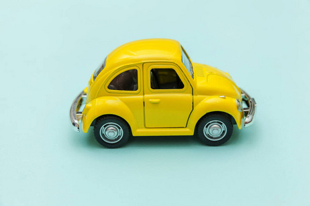 黄色复古复古玩具车孤立在蓝色粉彩彩色背景上