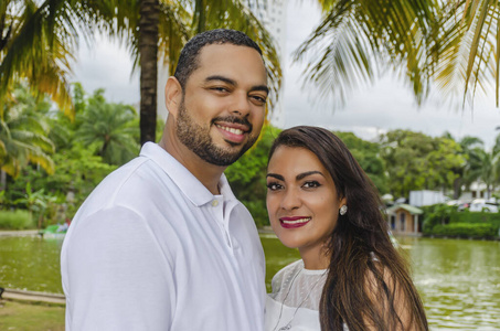 男女,与男孩患有自闭症,幸福地在一个户外的公园里合影,三人欢笑相拥