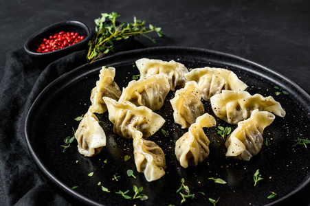 肉馅的日式饺子。黑色背景。俯视图