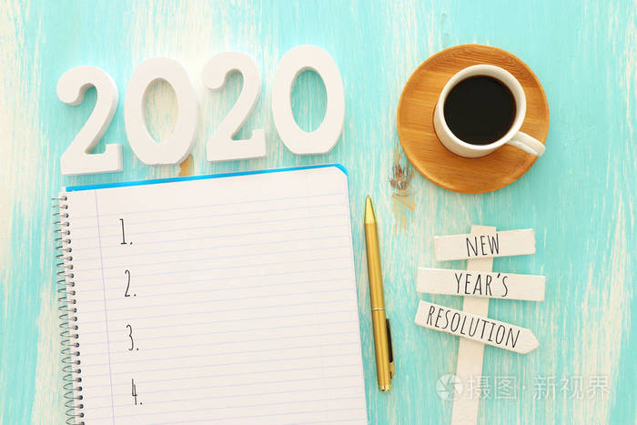 top view 2020目标列表的商业理念，带笔记本电脑，蓝色木制桌子上的咖啡杯