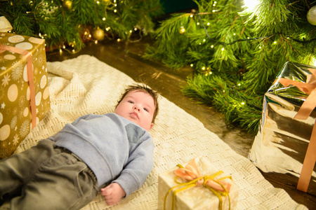 一个孩子在圣诞树旁。小男孩庆祝圣诞节。宝宝的第一个圣诞节。