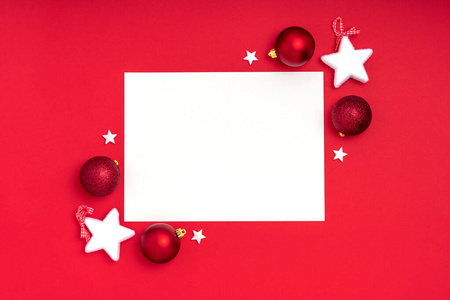 新年和圣诞节相框组成。红色背景上有圣诞装饰的白纸。俯视图，平面布置，复制空间