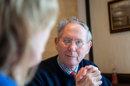 老人在保持眼神交流的同时专心倾听照片