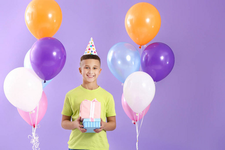 彩色背景上有生日气球和礼物的小男孩