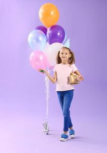 彩色背景上有生日礼物和派对风机的小女孩