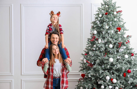 家里美丽的圣诞树旁有一个幸福的家庭