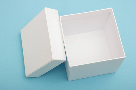 Empty, open white gift box on blue background with copy space