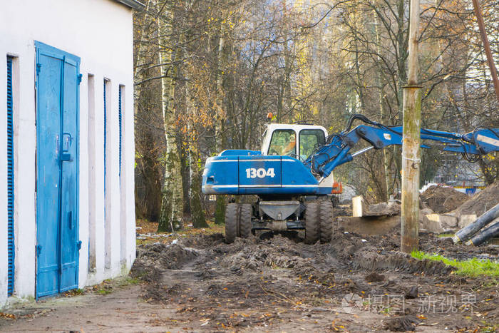 蓝色挖掘机在公园里从事挖掘工作