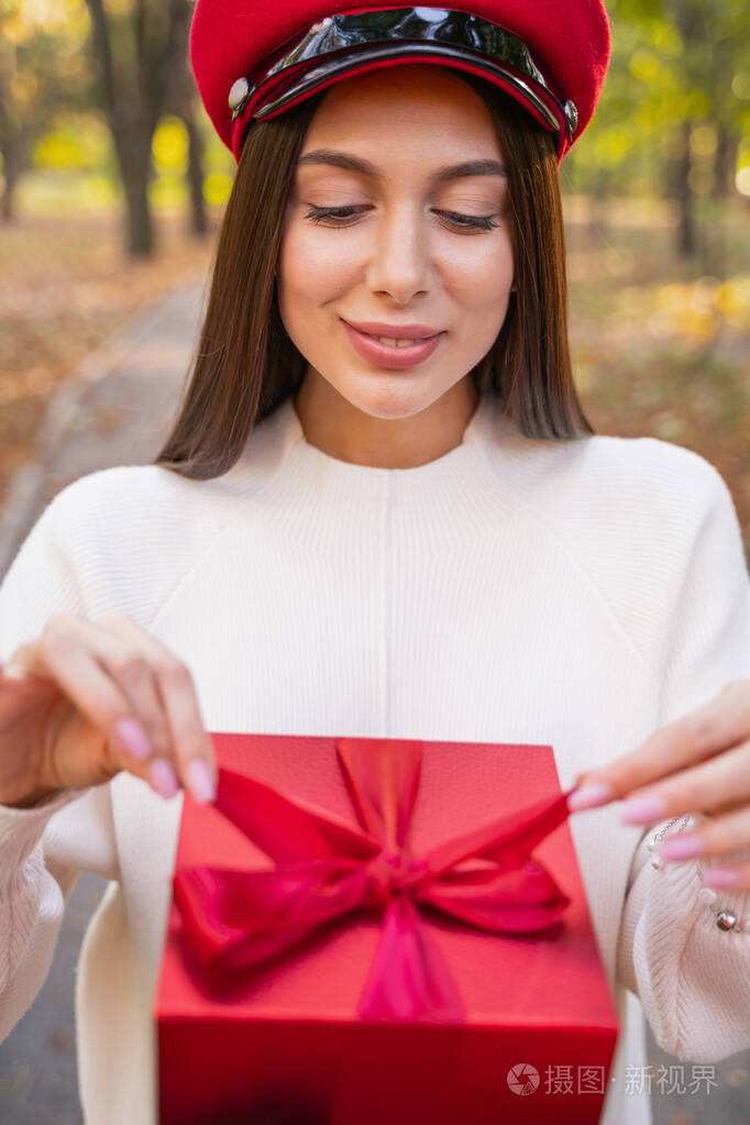美丽的黑发女孩低头看着盒子