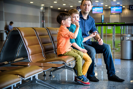 Mother and two brother boy son pointing at taking off airplanes 