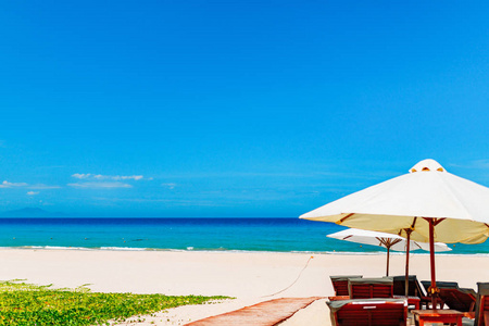 Empty white sand beach and parasol, blue sky