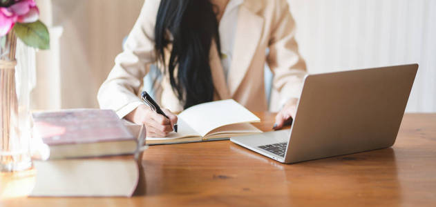 Cropped shot of businesswoman working on her project while writi