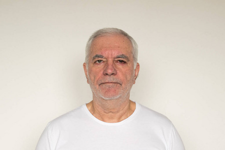 old man senior  white t shirt closeup next to the wall healthy 