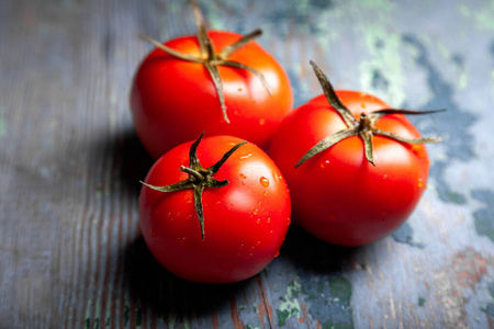 番茄加滴水。全景深。新鲜的红色成熟西红柿，用作烹饪原料，背景为深色。收获西红柿。俯视图