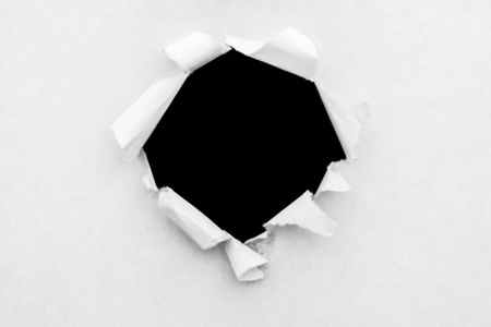 白纸上的圆孔，边缘被撕破，里面有一个黑色的孤立的背景。