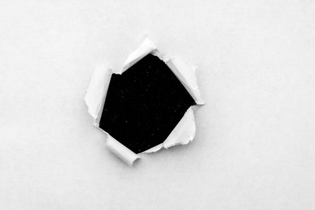白纸上的一个圆孔，边缘撕破，里面有黑色背景，里面有宇宙中五颜六色的太空恒星。一张可以看到宇宙的纸洞。