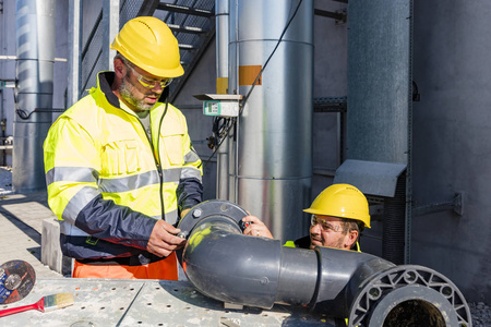 装配pvc管道的工人水管修理槽热水器服务修理热水器的技师控制面板