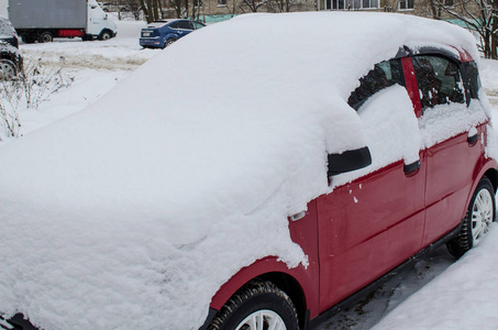 勃艮第车停在雪地下的停车场里