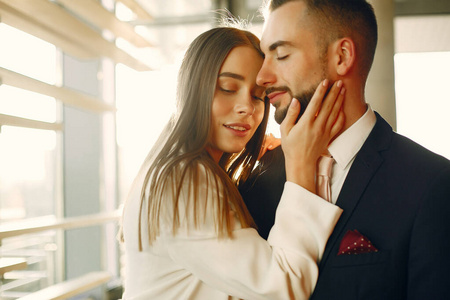 Elegant couple in a suits spend time in a cafe