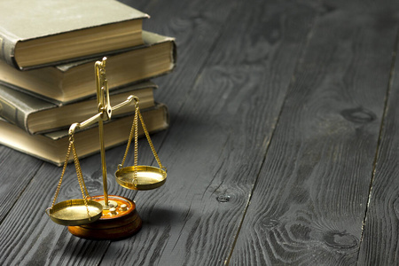 的法律书与木制法官木槌放在法庭或执法办公室的桌子上孤立的白色背景