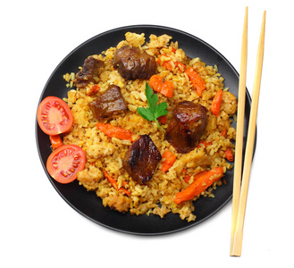 pilaf with meat on black plate isolated on white background. top